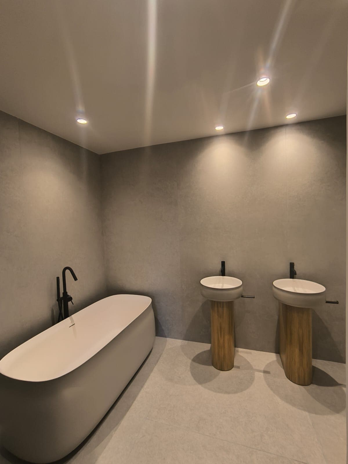 Suite con bañera exenta y doble lavabo sobre pedestal de madera