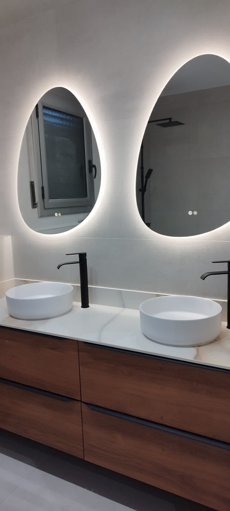 Baño con doble lavabo y espejos retroiluminados