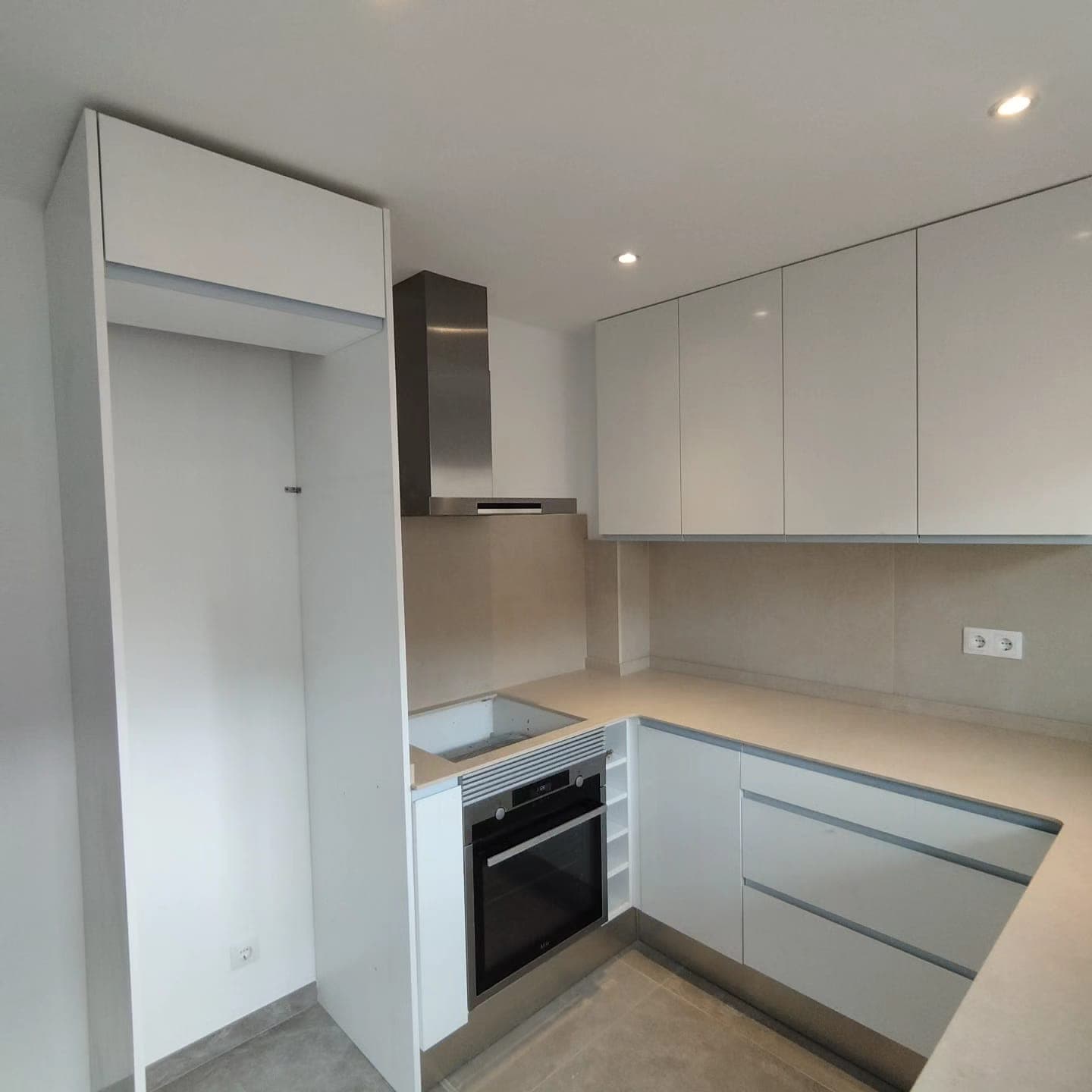 Cocina en U con acabados blancos reformada por Domus Lux